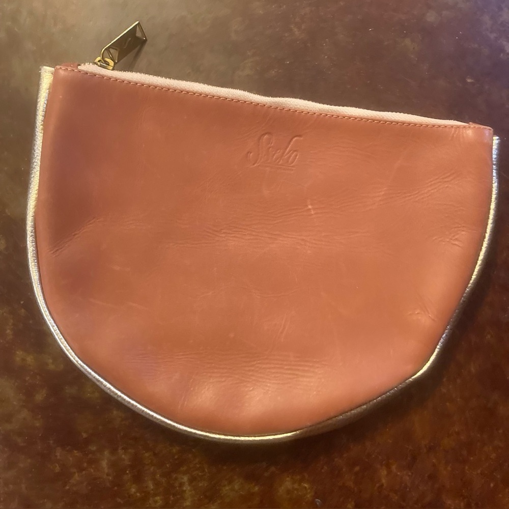 Sseko Handheld Clutch reddish brown leather with gold trim.